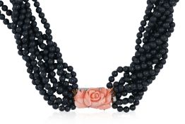 A MULTI-STRAND BLACK BEAD NECKLACE WITH CARVED CORAL SET CLASP