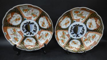 A pair of Japanese ceramic plates, hand painted repeated floral motif, a/f (repaired, cracked,