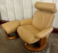 A tan leather and beech revolving lounge chair and ottoman