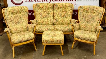An Ercol Blonde elm and beech Jubilee four piece lounge suite, comprising; settee, pair of armchairs