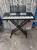 A pre-owned Yamaha PSR-E233 electronic keyboard complete with stand, music books, metronome and head