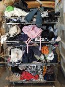 A large quantity of assorted clothing in four baskets.