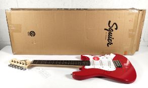 A Fender Squier Mini Stratocaster 3/4 size, Dakota Red, box opened.