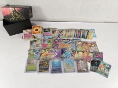 A quantity of assorted Pokemon TCG trading cards all inside a small storage box.