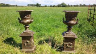 PAIR ORNATE CAST IRON URNS ON PLINTHS IN ANTIQUE GREEN FINISH
