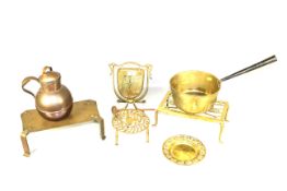 Three brass trivets, dinner gong, brass saucepan with metal handle, copper pot and a small brass