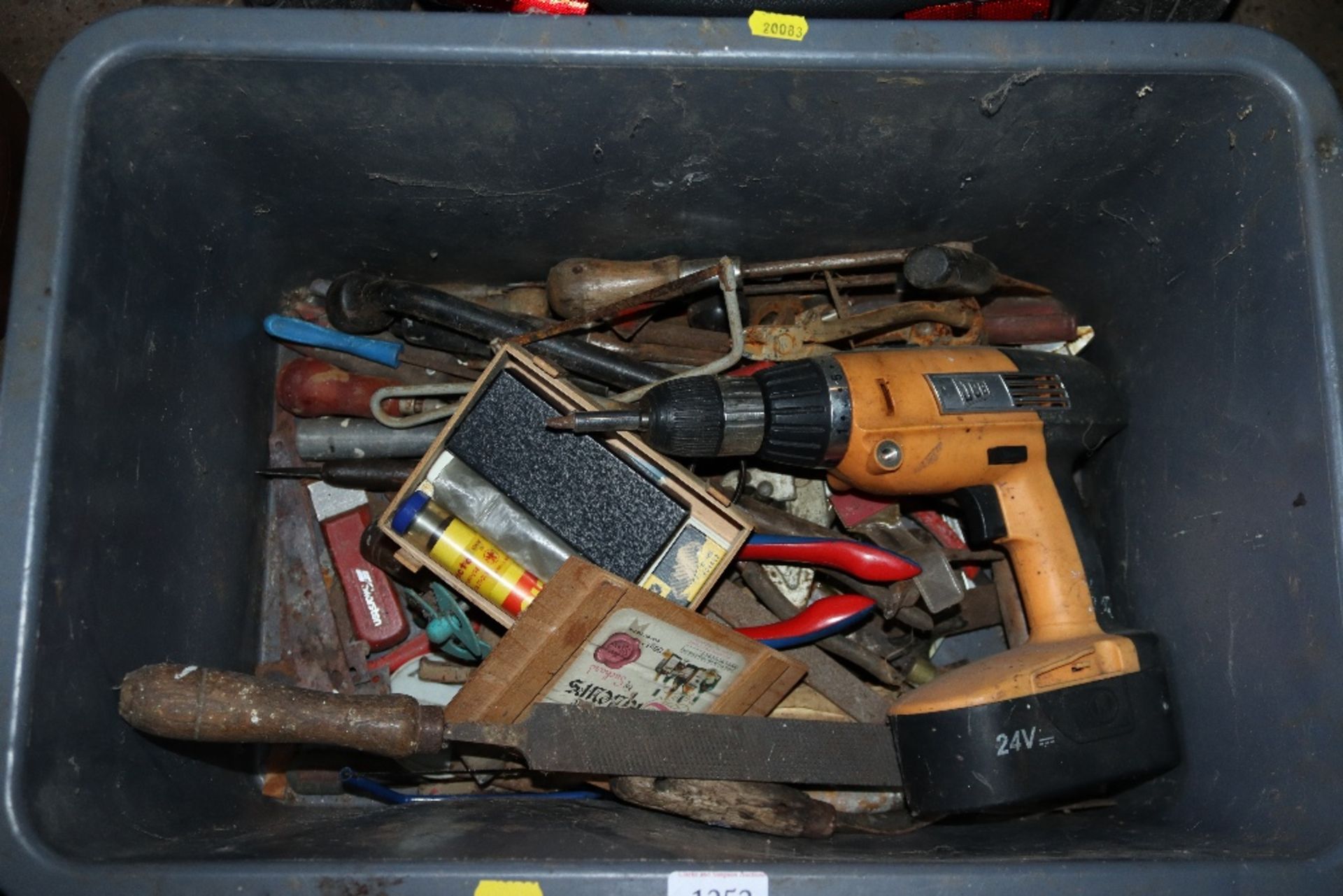 A box containing a JBC cordless drill and various hand tools