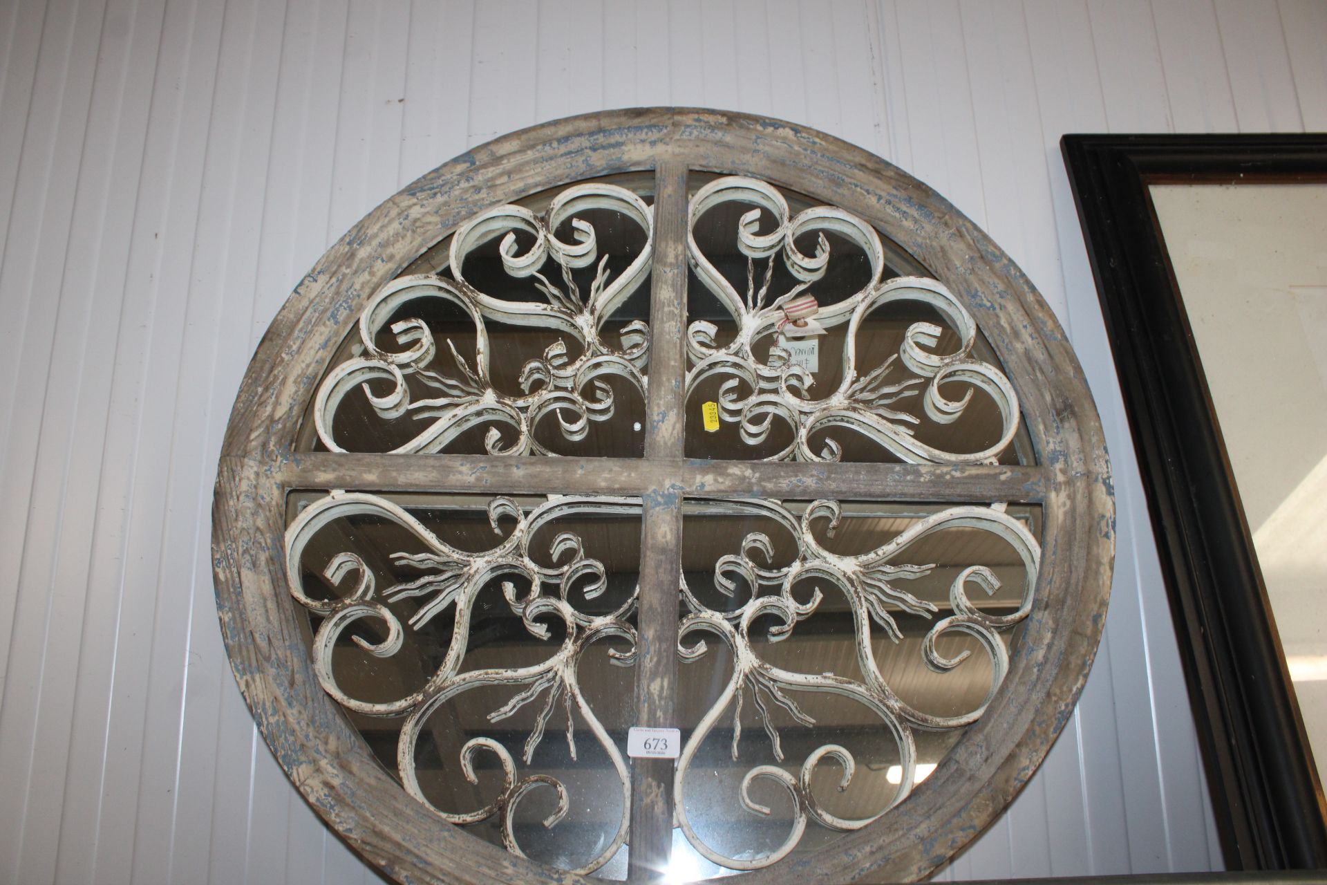 A wooden framed and wrought iron decorated circula