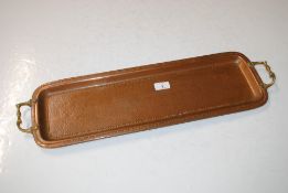 A copper and brass handled tray with spot hammered