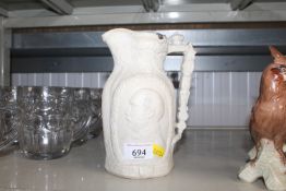 A Prince Albert Parian Ware style jug, lacking lid
