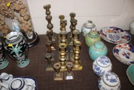 A collection of various brass candlesticks