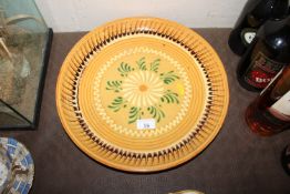 A large continental pottery charger with slipware