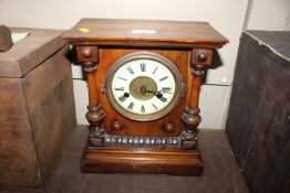 A late Victorian walnut cased mantel clock with ei
