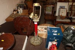 A decorative ornate brass and wood table lamp