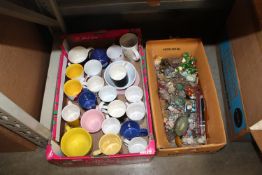 Two boxes containing various mugs, figures etc.
