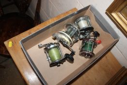 A box containing four fishing reels to include two