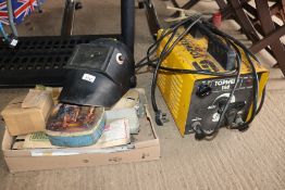 A Top Weld 140 welder and a box containing a welding mask and rods
