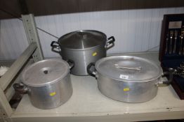 Three large stainless steel cooking pans