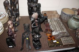 Four African hardwood carved figures and a figural decorated three legged stand