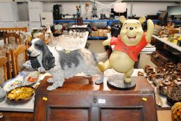 A figure of Winnie the Pooh and a model of a spaniel