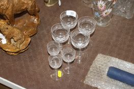 A set of four Greek key decorated cut wine glasses and three matching sherry glasses