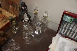 Five various decanters and stoppers, four having silver collars, one with floral painted decoration