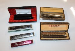A box containing Hohner and other mouth organs