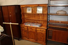 A pine dresser raised on cupboard base fitted three drawers