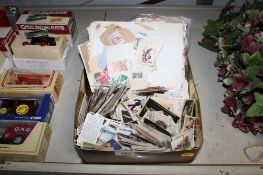 A box containing various cigarette cards and loose stamps