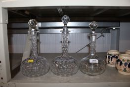 A pair of glass decanters and stoppers numbered to base together with one other glass decanter and