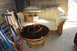 A wicker and cane two seater conservatory settee with cushions and matching pair of circular black