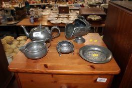 A pewter bachelors teapot, a spot hammered pewter jug, a circular tray, a sugar scuttle and a salt