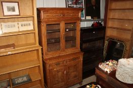 A glazed pine bookcase, the upper section fitted two shelves, the lower section fitted two drawers