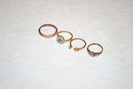 A rolled gold ring set with white stones and three dress rings