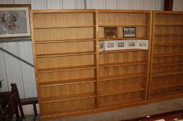 A light oak open fronted bookcase in two sections, each section fitted six adjustable shelves,