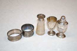 Two silver napkin rings; a small silver trophy cup AF; a silver pepper pot, 70gms total weight and a