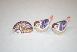 A Royal Crown derby paperweight in the form of a cat and two others in the form of birds
