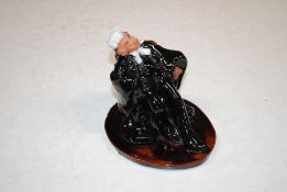 A Chelsea pottery figure in the form of a seated judge