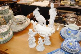 An Oriental blanc de chine figurine; cherub ornaments; cherub decorated vase and a parrot