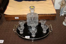An Art Deco design cut glass seven piece liqueur set and an oval galleried black glass tray