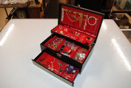 A cantilever jewellery box and contents of various costume jewellery to include bracelets,