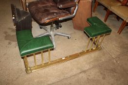 A brass extending and green leather upholstered club fender