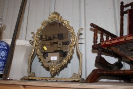 A brass swing framed mirror, decorated with cherub
