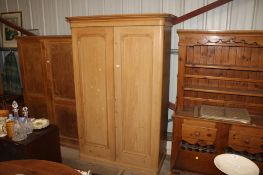 A Victorian stripped pine wardrobe, the interior fitted four drawers and hanging rails