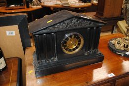 A black slate two-hole mantel clock with architectural form