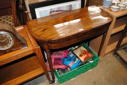 A 19th Century mahogany fold-over card table raised on ring turned supports AF