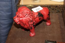 A red painted cast iron lion of small proportions