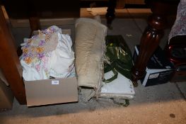 A small pattern rug and a collection of table linen and bed linen