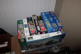 A box containing a quantity of various puzzles to include Wasgij and Mike Jupp
