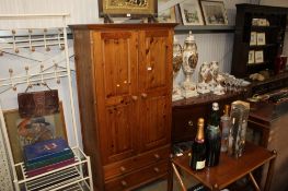 A pine two door wardrobe fitted two drawers
